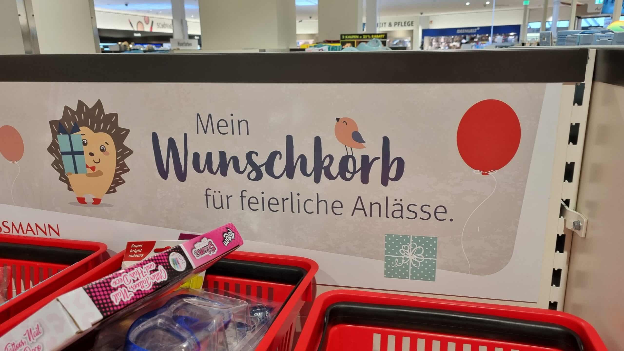 Ein Werbeschild in einer Rossmannfiliale bewirbt den Rossmann Wunschkorb