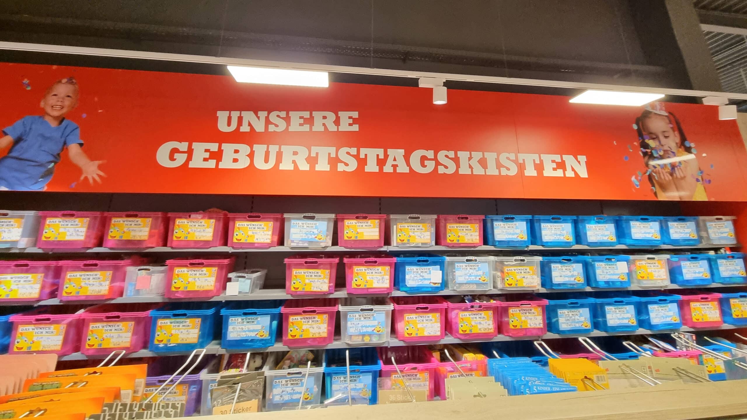 Ein Regal mit Geburtstagskisten in einer Toys World Filiale